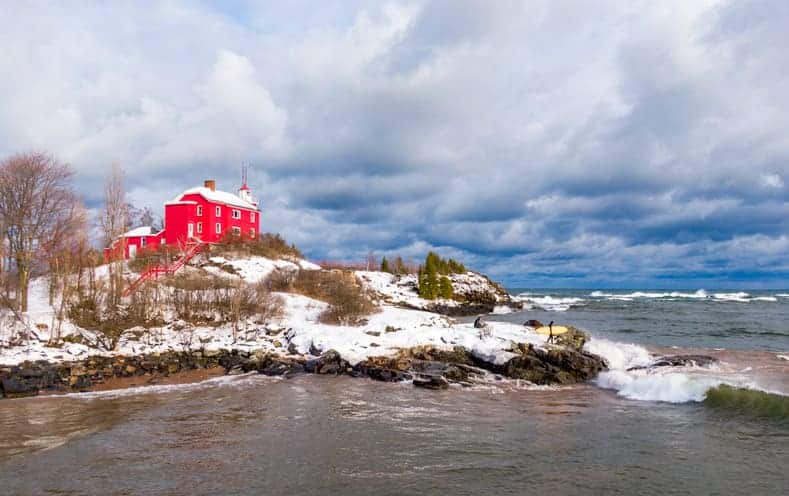 Winter surfing in Marquette at maritime lighthouse